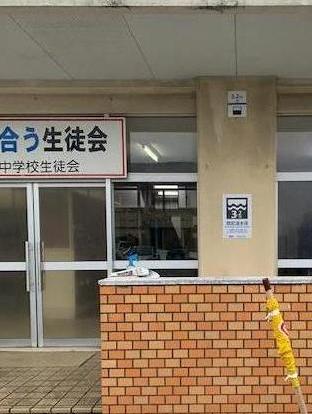 想定浸水深表示板が、実際の水深メートルに合わせて建物入り口横の柱に貼られている写真