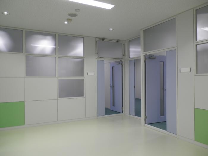 廊下から撮られた3つの薄い青色のドアが開いている写真