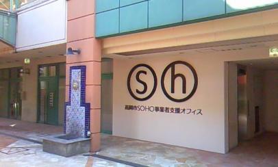 石タイル張りの床面やパネル壁・柱面ごとにそれぞれ異なるパステルカラーに塗り分けられたきれいな施設内に設けられた高岡市SOHO事業者支援オフィスの外観の写真