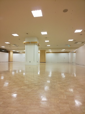 ベージュの床に白い柱が建っている広い室内の写真