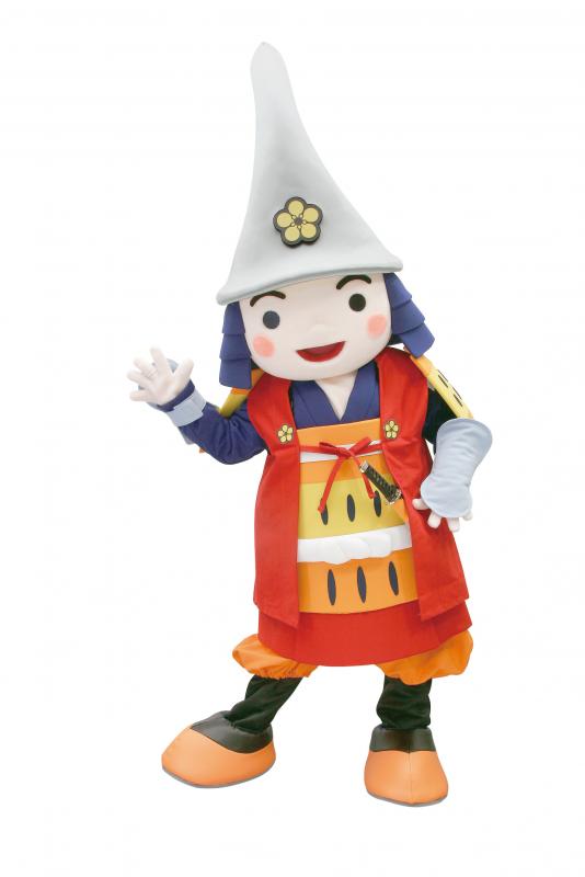 赤い鎧を着たキャラの着ぐるみが右手を振っている写真