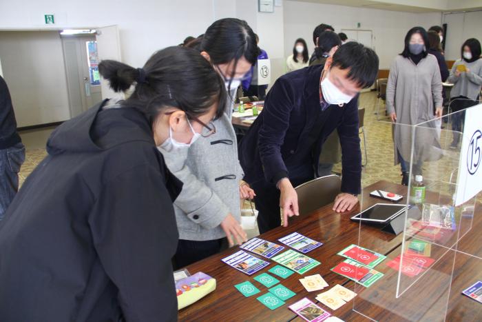 テーブルに並べられたカードを元にお互いの意見などを相談し合う参加者たちの写真
