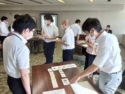 室内でカードゲーム「SDGs de 地方創生」をプレイする人々の様子の写真