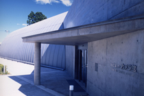 入り口に参画の屋根が付いているコンクリートでできた建物の写真