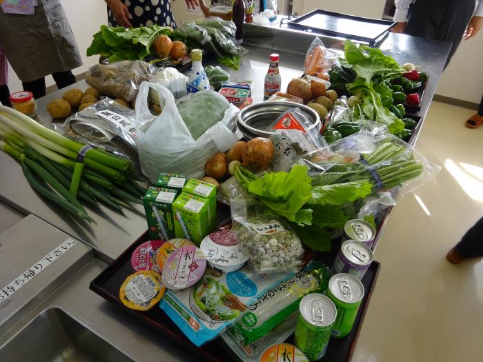 大量の野菜やお茶などが調理テーブルの上に並べられている写真