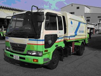 上半分が白、下半分が緑色に塗られている高岡市直営のごみ収集車の写真