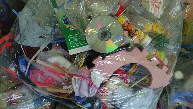 ペットボトル、CD、ウレタンマット等の雑多な異物が混交したごみ袋の写真