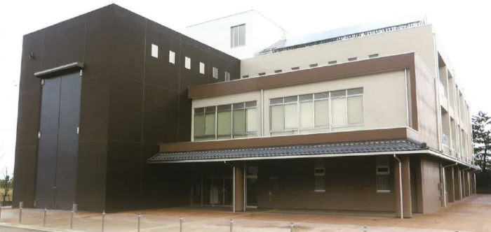 段々状になっている3階建ての建物と大きな黒い建物が並んでいる写真