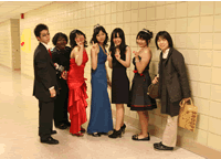 ドレスやスーツを着た人たちが並んでいる写真