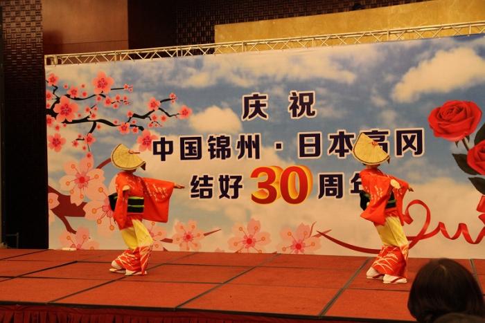 笠を身に着けた2人の和装の女性が踊る写真