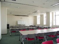 机が向かい合わせに並んでいる会議室の写真