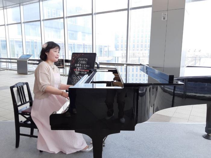 ピアノを演奏して見せる石見由美子女史の写真