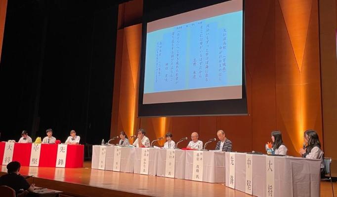 スクリーンに映し出された短歌についてバトルを繰り広げている高校生万葉短歌バトルの写真