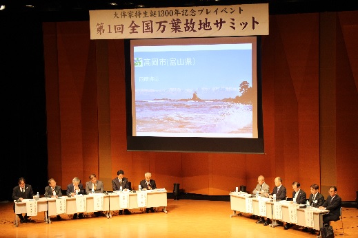 高岡市生涯学習センターホールのステージ上における、第1回全国万葉故地サミットの開催風景の写真