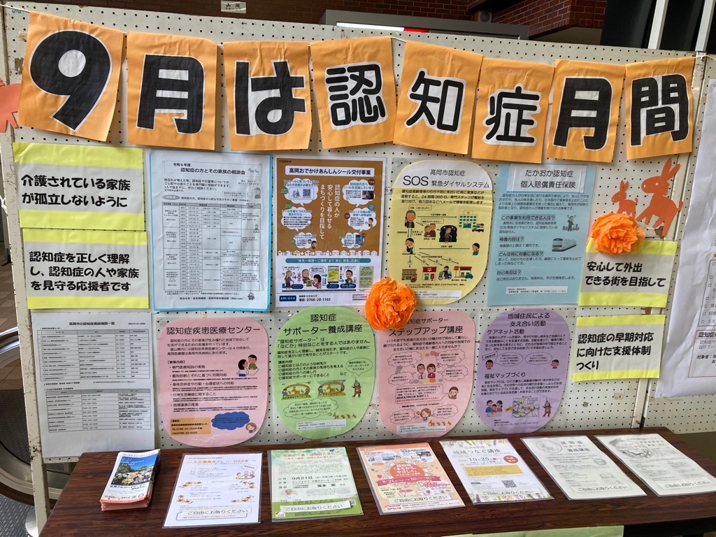 「9月は認知症月間」と装飾された展示板があり、その手前に関連する資料が並べられている様子の写真