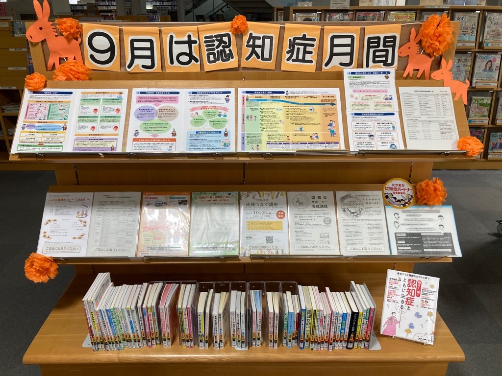 「9月は認知症月間」と装飾された本棚があり、それに関連する本やリーフレット等が並べられている様子の写真