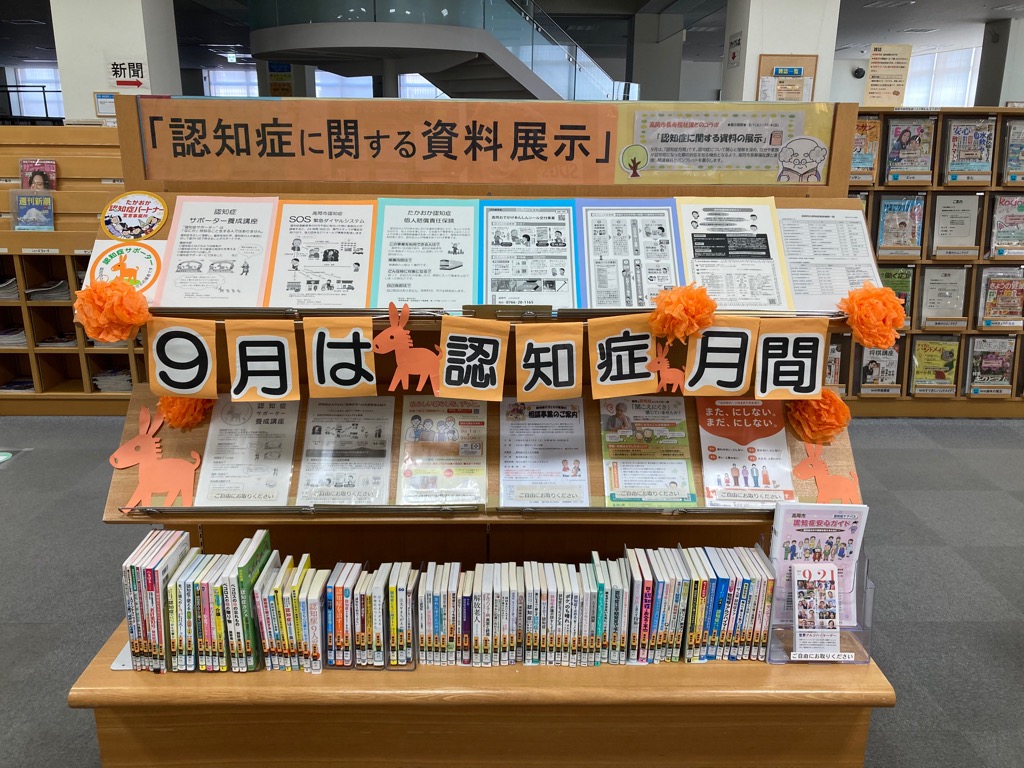「9月は認知症月間」と装飾された本棚があり、それに関連する本やリーフレット等が並べられている様子の写真