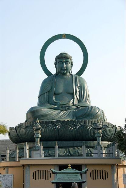 屋外に祀られている青銅色の大仏の写真