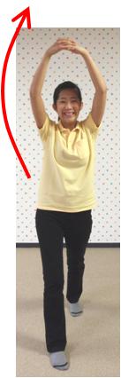 頭上で腕を組んだ女性に赤い矢印が添えられている写真