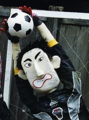 サッカーボールを受け止めるユニフォームを着たカカシの写真