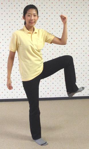 左膝を横に上げて左腕を曲げた女性の写真