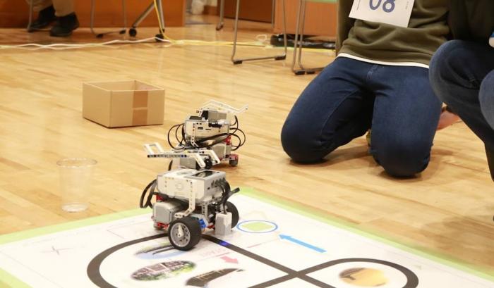 シート上のラインに沿って走る、競技参加ロボットの写真