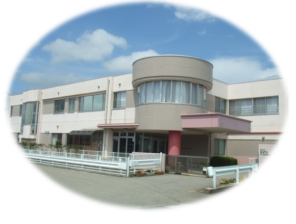 二階建ての横に長い建物がふちのぼけた楕円形に収められた写真