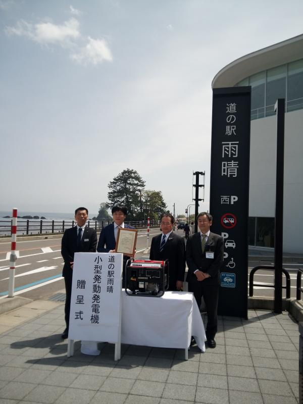 贈呈式に臨んで小型発動発電機を前に記念撮影に応じる、角田市長と海野JRCA北陸支部長等の写真