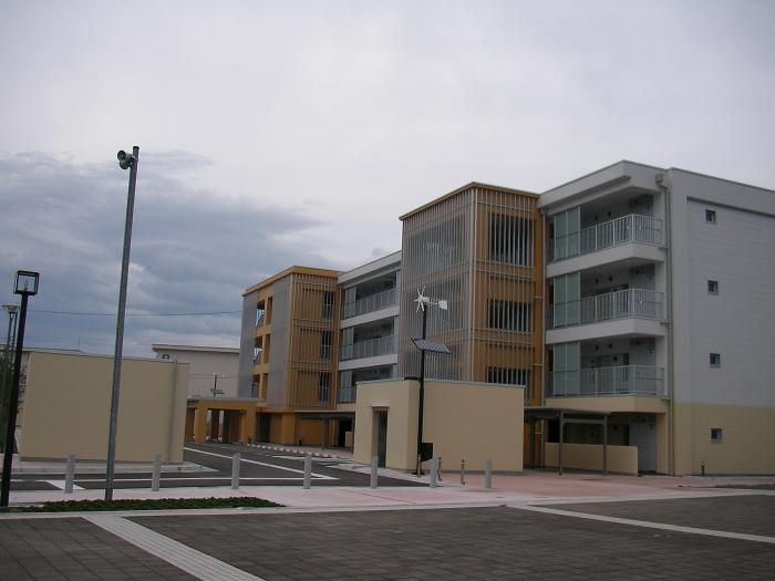 4階建ての灰色の市営住宅の写真