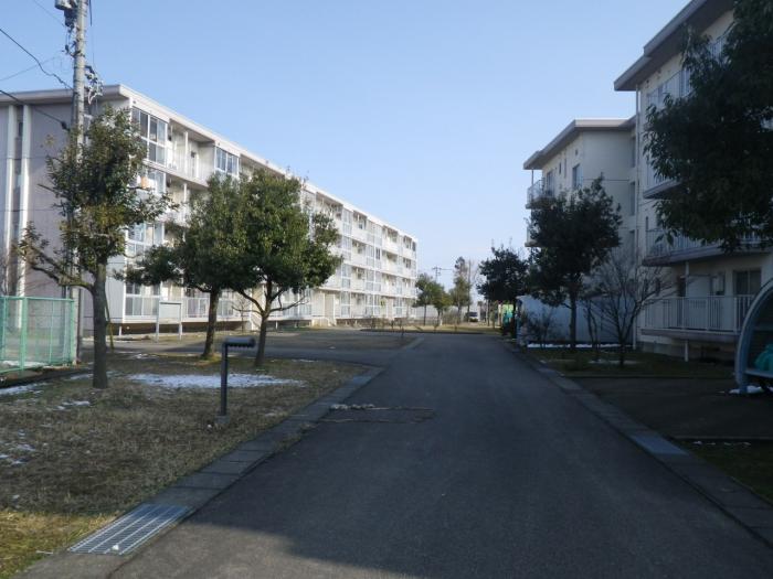道を挟んで向かい合って建っている4階建ての建物の写真