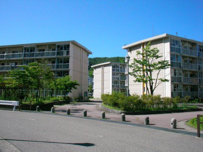 二手に分かれた道の周りに立ち並ぶ4階建ての建物の写真