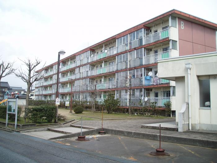 児童公園に面した4階建ての建物の写真