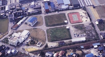 街中で住宅に囲まれた上関浄水場を空から俯瞰している写真