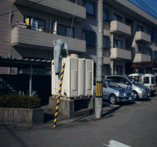 住宅地にある白い箱型の貯水槽水道の写真