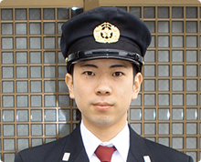制帽をかぶり、警備服を着た消防団の森沢 哲さんが正面を向き写っている写真