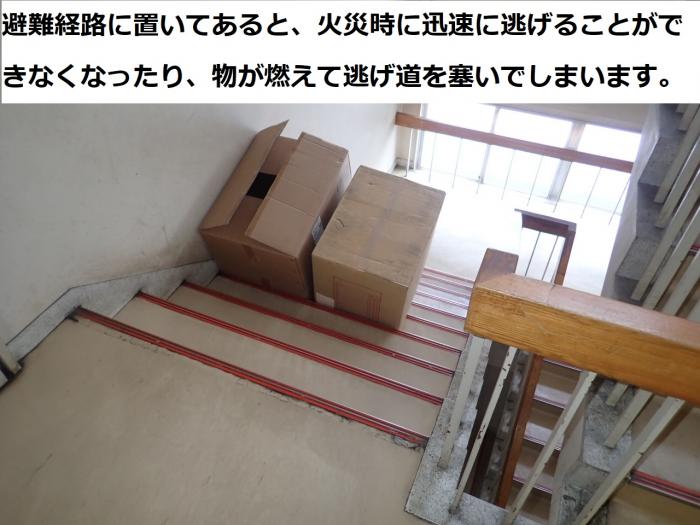 「避難経路に置いてあると、災害時に迅速に逃げることができなくなったり、物が燃えて逃げ道をふさいでしまいます。」と書かれた文字と、階段の途中にダンボールが置かれた写真