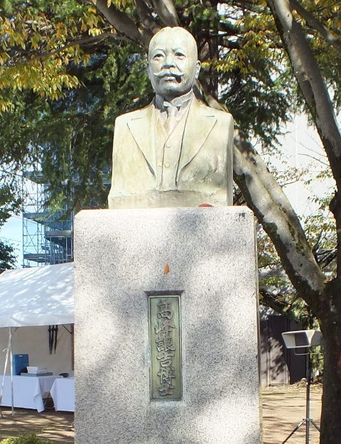 「高峰譲吉博士」と台座に文字が入ったスーツ姿の男性の胸像の写真