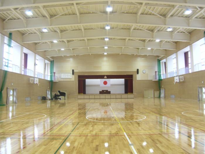 日本国旗の飾られた舞台がある体育館の写真