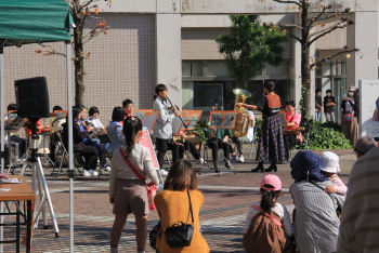 吹奏楽部の演奏に聴き入る人たちの写真