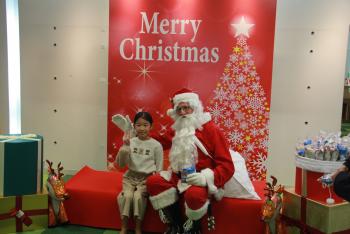 ベンチに腰掛けたサンタさんと幼い少女の写真