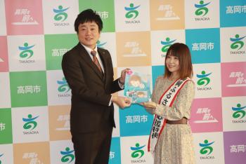 寄贈するCDを門田市長に手渡す島香織さんの写真