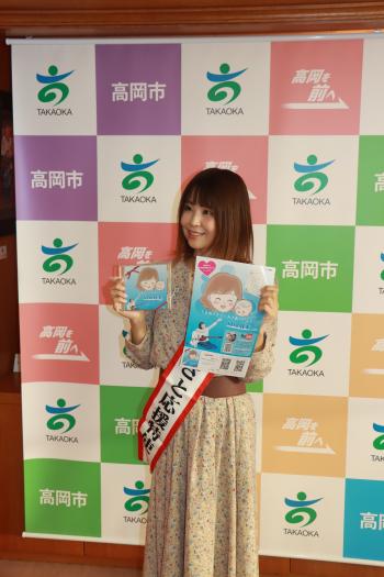 「うまれてきてくれてありがとう」のCDとポスターを手に微笑む島香織さんの写真