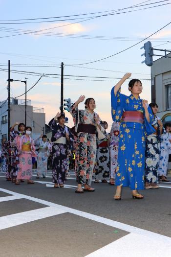 路上で、浴衣を着た女子生徒たちが、踊りを踊っている写真