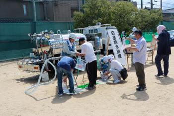 給水車から容器に水を受け取る訓練の写真
