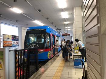 駅に到着した青い市街電車の写真