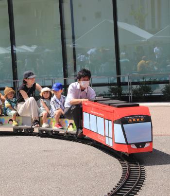 家族連れを載せて走るミニチュア列車の写真