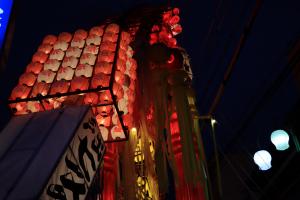 夜空に向かって高く、無数の紅白の提灯が飾られている写真