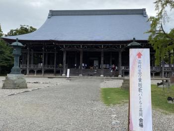 壮大な勝興寺本堂の前に、短歌バトルの開催を示す看板が据えられている写真