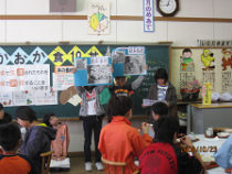 紙を持ってクイズを出している給食委員会の児童たちとクイズに挑戦している児童たちの写真
