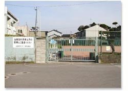 緑色の柵で締め切られている庭球場入り口前の写真